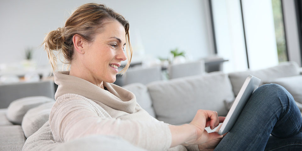 Bild, Frau mit Tablet auf Sofa