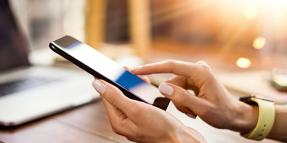 Bild, weibliche Hand tippt auf Handy